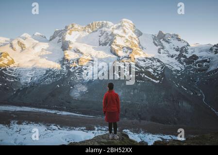 Donna in piedi sulla roccia del Ghiacciaio Gorner in Vallese, Svizzera Foto Stock