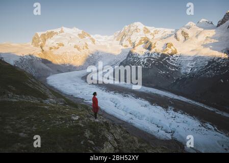 Donna in piedi sulla roccia del Ghiacciaio Gorner in Vallese, Svizzera Foto Stock