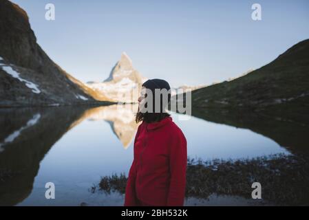 Donna in piedi presso il monte Cervino e il lago in Vallese, Svizzera Foto Stock