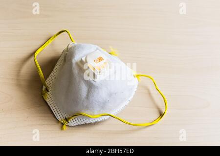 Usato N95 maschera respiratoria scartata su un tavolo; concetto per l'attuale carenza di PPE nella battaglia contro COVID-19 Foto Stock