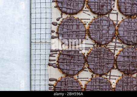 Biscotti fatti in casa con cioccolato fondente e hobbo su una rastrelliera metallica Foto Stock