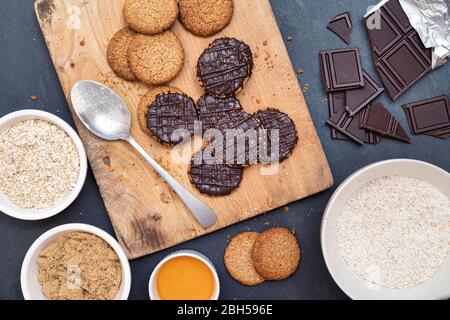 Biscotti fatti in casa con hobbo ricoperti di cioccolato fondente e ingredienti Foto Stock