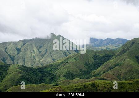 Vista panoramica del pittoresco paesaggio montano nel centro di Panama, con lussureggianti colline verdi sotto un cielo nuvoloso. Foto Stock