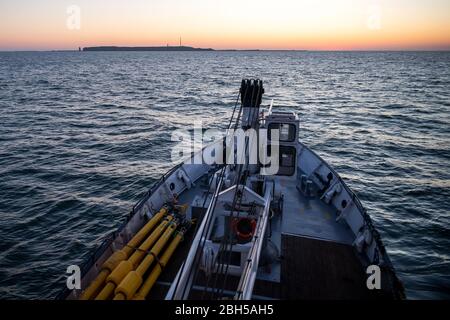 23 aprile 2020, Schleswig-Holstein, Helgoland: Lo strato di boa 'Lev Taifun' arriva poco prima dell'alba al campo di prova futuro fuori Helgoland. Il segnale di partenza per un grande campo di test marittimo al largo di Helgoland: Gli scienziati del Centro di test per le tecnologie marittime hanno utilizzato boe per contrassegnare un'area di tre milioni di metri quadrati non lontano dall'isola del Mare del Nord. Esso è destinato a fornire in futuro impianti di prova per la robotica marittima. Produttori e scienziati possono testare diversi scenari. Ad esempio, i veicoli subacquei autonomi per turbine eoliche offshore possono essere tes Foto Stock