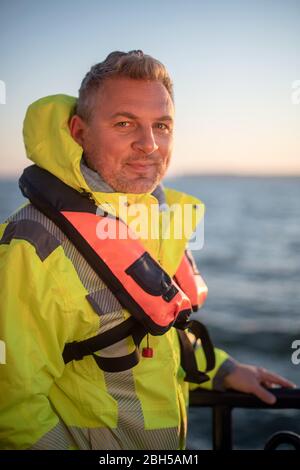 23 aprile 2020, Schleswig-Holstein, Helgoland: Hanno Schnars, responsabile della business unit Maritime Technologies presso l'Istituto Frauenhofer per la tecnologia di produzione e la ricerca sui materiali applicati (IFAM), è in piedi al railing del boa strato 'Lev Taifun' nella prima mattina. Segnale di partenza per un grande campo di test marittimo al largo di Helgoland: Gli scienziati del Centro di test per le tecnologie marittime hanno utilizzato tonnellate per contrassegnare un'area di tre milioni di metri quadrati non lontano dall'isola del Mare del Nord. Esso è destinato a fornire in futuro impianti di prova per la robotica marittima. Produttori e sci Foto Stock