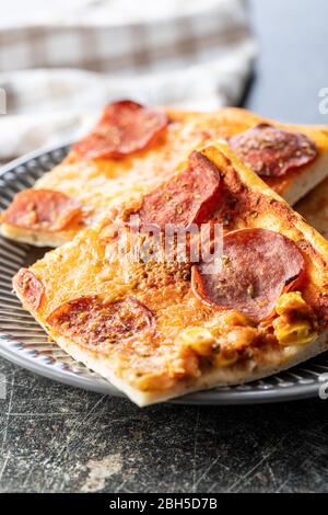 Pezzi di pizza italiana fatta in casa sul piatto. Foto Stock