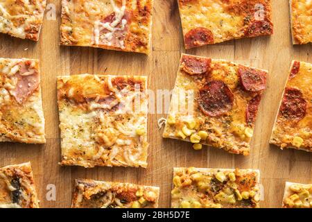 Pezzi di pizza italiana fatta in casa su carta da forno. Vista dall'alto. Foto Stock