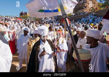 Un importante anziano reale è scortato con i sostenitori, ombrelli in una cerimonia sacra Timkat festival ad Axum. In Etiopia, Africa. Foto Stock