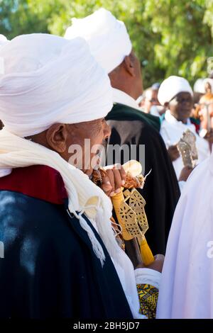 Un anziano vestito regalmente, con canna, ascolta durante una cerimonia Timkat ad Axum. In Etiopia, Africa. Foto Stock