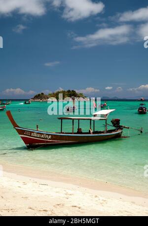 Taxi barca sulla spiaggia alba thailandia asia, con acqua blu chiaro e cielo blu, formato verticale Foto Stock