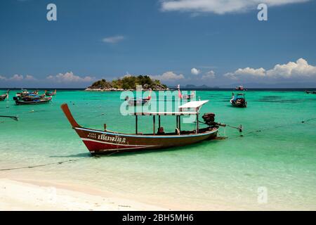 Taxi barca sulla spiaggia alba thailandia asia, con acqua blu chiaro e cielo blu, isola di koh usen sullo sfondo. Foto Stock