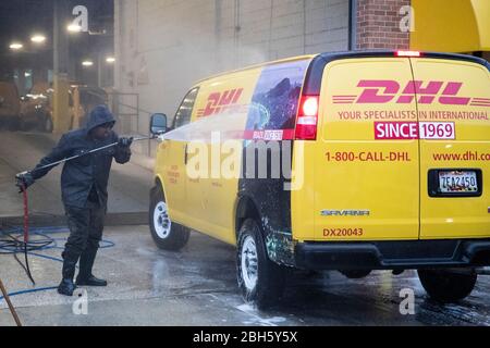 Washington, DC, USA. 23 aprile 2020. Un uomo pulisce un veicolo di consegna DHL a Washington, DC 23 aprile 2020. La Camera dei rappresentanti degli Stati Uniti il giovedì ha passato un pacchetto di sollievo da 484 miliardi di dollari per aumentare i finanziamenti per le piccole imprese, gli ospedali e i nuovi test di coronavirus. Credit: Ting Shen/Xinhua/Alamy Live News Foto Stock