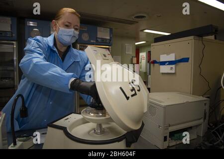 NEW YORK (21 aprile 2020) il Lt. Rebekah Johnson, capo del reparto di laboratorio e responsabile della banca del sangue, utilizza una centrifuga per processare un campione di sangue a bordo della nave ospedaliera USNS Comfort (T-AH 20). Il comfort si preoccupa dei pazienti critici e non critici indipendentemente dal loro stato COVID-19. Comfort sta lavorando con Javits New York Medical Station come sistema integrato per alleviare il sistema medico di New York City, a sostegno del Northern Command's Defence Support of Civil autorità come risposta alla pandemia COVID-19. Credit: Storms Media Group/Alamy Live News Foto Stock