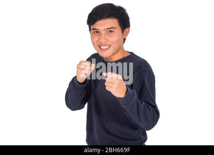 La foto di un ragazzo sorridente sta mostrando i suoi due pugni sfondo bianco Foto Stock