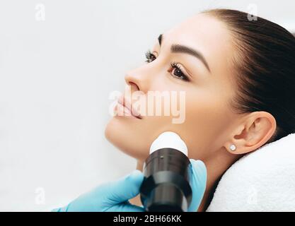 Ringiovanimento della pelle del viso con l'aiuto di onde acustiche, primo piano viso di una bella donna Foto Stock