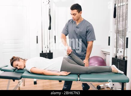 donna in visita al suo fisioterapista. paziente che fa esercizio per il trattamento articolare Foto Stock