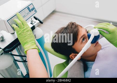 Bambino che ottiene la sedazione di inalazione mentre il trattamento dei denti alla clinica dentale. Trattamento denti bambino Foto Stock