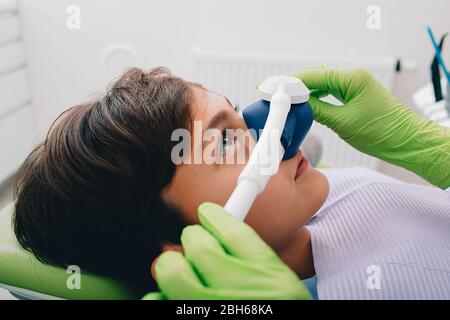 Bambino che ottiene la sedazione di inalazione mentre il trattamento dei denti alla clinica dentale. Trattamento denti bambino Foto Stock