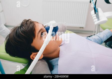 Bambino che ottiene la sedazione di inalazione mentre il trattamento dei denti alla clinica dentale. Trattamento denti bambino Foto Stock