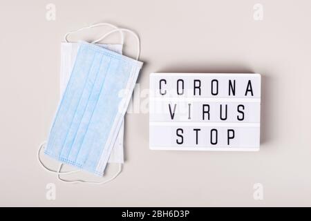 2019-nCoV Coronavirus originario di Wuhan, Cina. Maschera medica e lightboard con parole Coronavirus STOP. Concetto di trattamento. Foto Stock