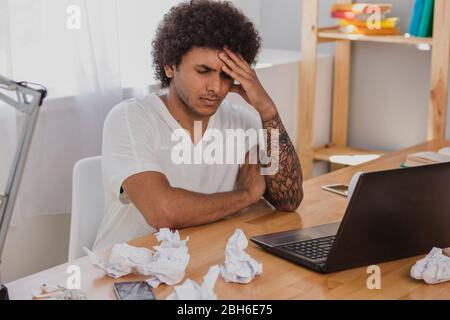Giornata di lavoro. Attraente uomo designer, sensazione di stanchezza, appoggiandosi la testa su mano e occhi chiusi. Foto Stock