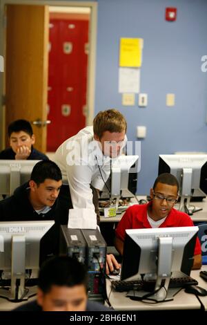 Dallas, Texas, 23 gennaio 2009: L'insegnante si appoggia con gli studenti del settimo e dell'ottavo grado nel laboratorio informatico alla Peak Preparatory Academy di Dallas est. La scuola è una scuola pubblica charter che ha mostrato una notevole crescita dei risultati degli studenti nei suoi cinque anni di storia. ©Bob Daemmrich Foto Stock