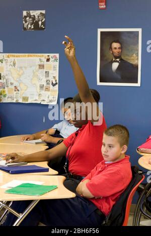 Dallas, Texas, 23 gennaio 2009: La studentessa nera alza la mano nella settima classe di inglese al Peak Preparatory Academy di Dallas est. La ragazza sembra aver raggiunto la pubertà mentre i suoi compagni di classe maschi più piccoli non hanno. ©Bob Daemmrich Foto Stock