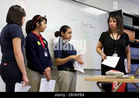 Dallas, Texas, 23 gennaio 2009: L'insegnante di sesso nero ascolta gli studenti mentre fanno una presentazione di gruppo durante la lezione di inglese per i settimo grado alla Peak Preparatory Academy di Dallas est. La scuola è una scuola di charter pubblica dove gli studenti indossano uniformi e ha mostrato una notevole crescita dei risultati degli studenti nei suoi cinque anni di storia. ©Bob Daemmrich Foto Stock