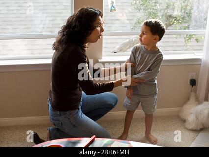 la mamma ispanica parla con il suo figlio di quattro anni arrabbiato a casa. SIG. ©Bob Daemmrich Foto Stock
