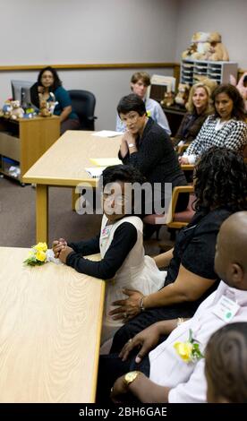 Austin, Texas, 20 novembre 2008: Celebrando la Giornata nazionale di adozione nel Texas centrale sono state 24 le famiglie che hanno adottato i bambini nelle cerimonie festive presso la Corte giovanile della contea di Travis. Alexus Giles (c) ascolta il procedimento in tribunale per assegnarla alla sua famiglia adottata di Anthony e Penora Giles (r). ©Bob Daemmrich Foto Stock