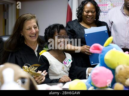 Austin, Texas, 20 novembre 2008: Celebrando la Giornata nazionale di adozione nel Texas centrale sono state 24 famiglie che hanno adottato i bambini in cerimonie festive alla corte Juvenile della contea di Travis. Alexus Giles sorride dopo che le carte sono firmate dal giudice Darlene Byrne (l) come madre Penora Giles (r) orologi. ©Bob Daemmrich Foto Stock