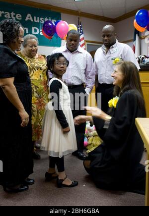 Austin, Texas, 20 novembre 2008: Celebrando la Giornata nazionale di adozione nel Texas centrale sono state 24 famiglie che hanno adottato i bambini in cerimonie festive alla corte Juvenile della contea di Travis. Alexus Giles (c) pone con la sua famiglia adottò e giudice Darlene Byrne (r). ©Bob Daemmrich Foto Stock