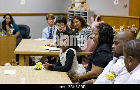 Austin, Texas, 20 novembre 2008: Celebrando la Giornata nazionale di adozione nel Texas centrale sono state 24 le famiglie che hanno adottato i bambini nelle cerimonie festive presso la Corte giovanile della contea di Travis. Alexus Giles (c) ascolta il procedimento in tribunale per assegnarla alla sua famiglia adottata di Anthony e Penora Giles (r). ©Bob Daemmrich Foto Stock