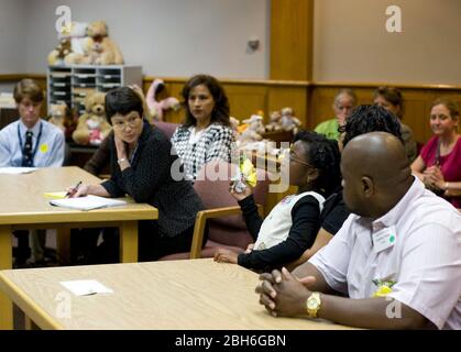 Austin, Texas, 20 novembre 2008: Celebrando la Giornata nazionale di adozione nel Texas centrale sono state 24 famiglie che hanno adottato i bambini in cerimonie festive alla corte Juvenile della contea di Travis. Alexus Giles (c) ascolta il procedimento in tribunale per assegnarla alla sua famiglia adottatrice di Anthony e Penora Giles (r). ©Bob Daemmrich Foto Stock