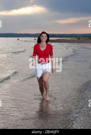 Austin, Texas 24 giugno 2009: Madre di trentotto anni di due che tiene fisicamente in forma passeggiate lungo una spiaggia nel Texas centrale. ©Bob Daemmrich Foto Stock