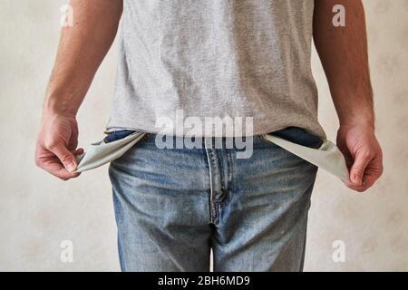 Tasche vuote capovolte. Il giovane uomo ha esaurito le tasche dei jeans. Foto Stock