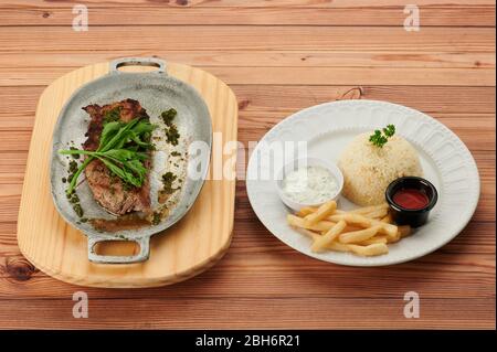 Tradizionale carne barbecue con patatine fritte su due piatti sopra la vista laterale Foto Stock