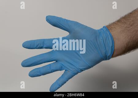 mano con guanti in lattice con fondo bianco Foto Stock