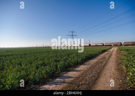 GB Railspedifire Merry andare in giro treno trasporto di carbone importato per la generazione di elettricità sulla costa orientale mainline passando i tralicci elettrici Foto Stock