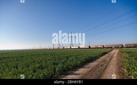GB Railspedifire Merry andare in giro treno trasporto di carbone importato per la generazione di elettricità sulla costa orientale mainline passando i tralicci elettrici Foto Stock