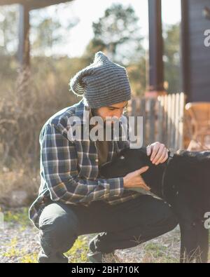 Ritratto di un uomo bearded con il suo vecchio cane e un bel tramonto sulla montagna Foto Stock
