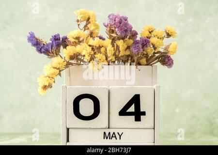 Calendario cubo bianco per maggio decorato con fiori su sfondo verde con spazio copia Foto Stock
