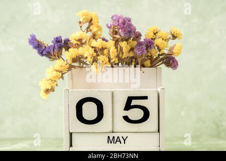 Calendario cubo bianco per maggio decorato con fiori su sfondo verde con spazio copia Foto Stock
