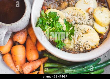 Ricetta tradizionale pentola calda con sugo di carne e patate guarnite con prezzemolo Foto Stock