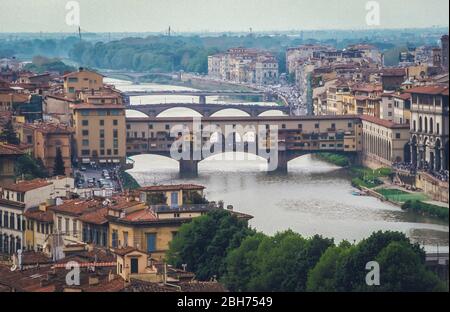 FIRENZE, TOSCANA, ITALIA - 2000: Vista elevata sull'Arno che mostra il ponte medievale in pietra Ponte Vecchio con il Ponte Santa Trinita a valle e il paesaggio urbano storico di Firenze Foto Stock