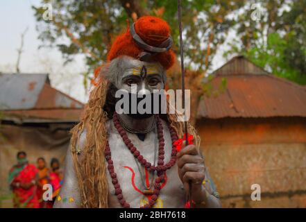 AGARTALA,TRIPURA,INDIA,12-04-2020 : gli artisti folkloristici stanno eseguendo i rituali di Shiber Gajan con la copertura del viso con stoffa e maschera , durante un blocco nazionale imposto dal governo come misura preventiva contro il COVID-19, nella periferia di Agartala, capitale dello stato nordorientale di Tripura, India. FOTO DI-ABHISEK SAHA Foto Stock