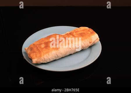 Sul piatto si trova lo shaurma - un piatto mediorientale di pita pane, cotto alla griglia, carne con l'aggiunta di spezie, salse e insalata di verdure. Foto Stock