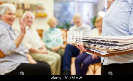 Lo psicoterapeuta distribuisce blocchi di disegno o tamponi di scrittura nella terapia di gruppo Foto Stock