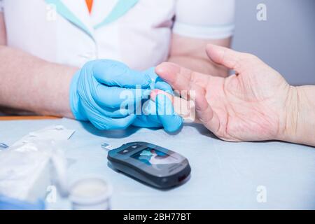 Infermiera medica che misura lo zucchero di anima con medicine.checking anziani moderni Glicemia del paziente.giornata mondiale del diabete-novembre 14.Test medico Foto Stock