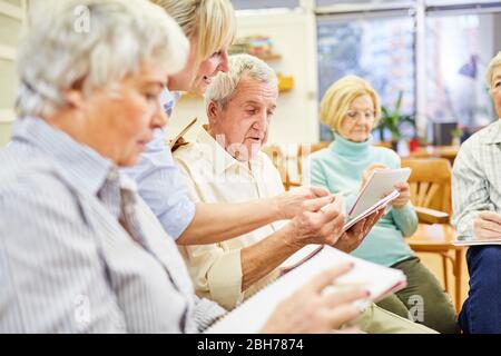 Un medico o terapista aiuta gli anziani a scrivere la terapia di scrittura Foto Stock